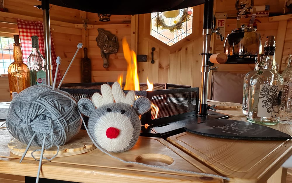 Interior of Arctic Cabin Grill Hut with fire burning and knitting