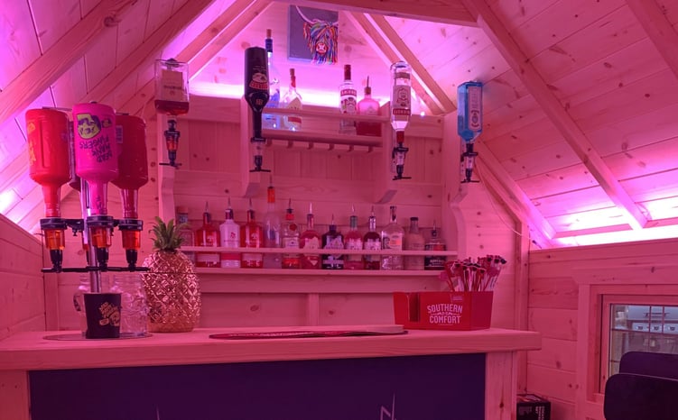 Interior of Arctic Cabin home garden bar with ice bucket, optics and drinks rack