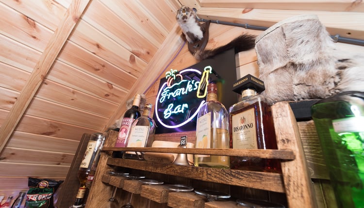 Close up of Arctic Bar BBQ cabin with neon sign, spirits and glasses