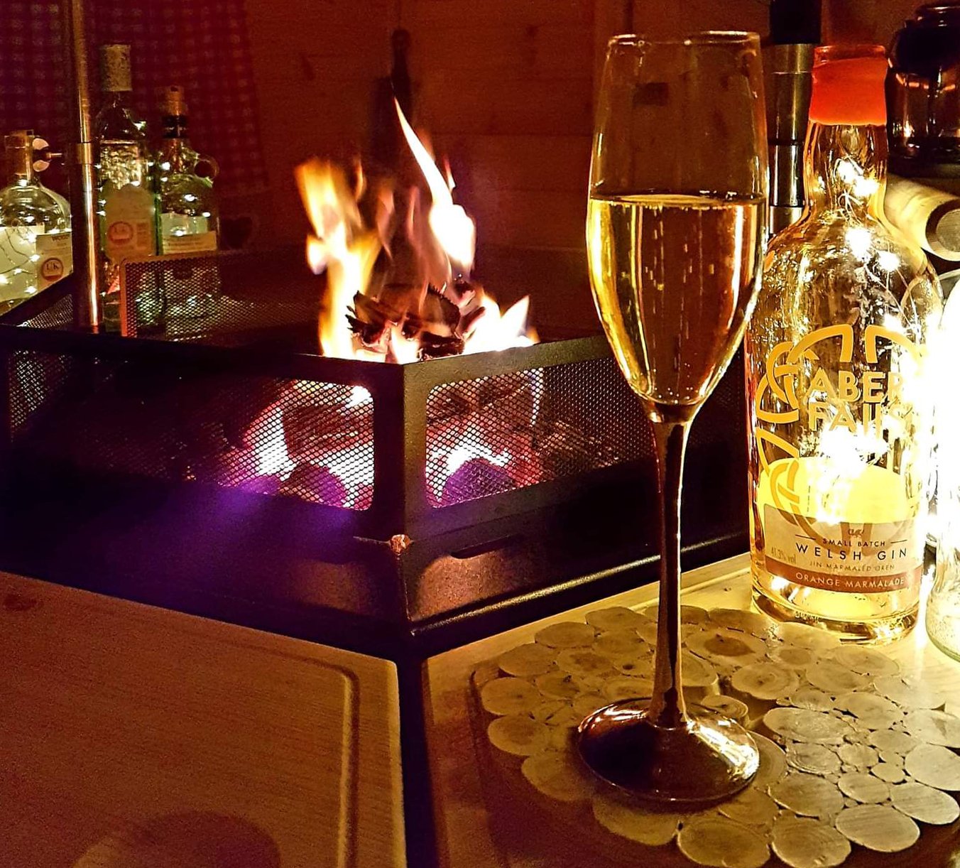 Interior of an Arctic Cabins BBQ hut with roaring fire, prosecco & gin