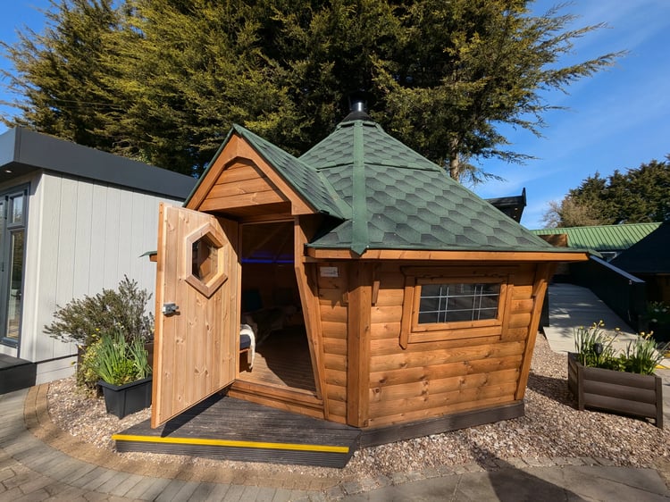 A 14m2 hexagonal BBQ log cabin with a green roof