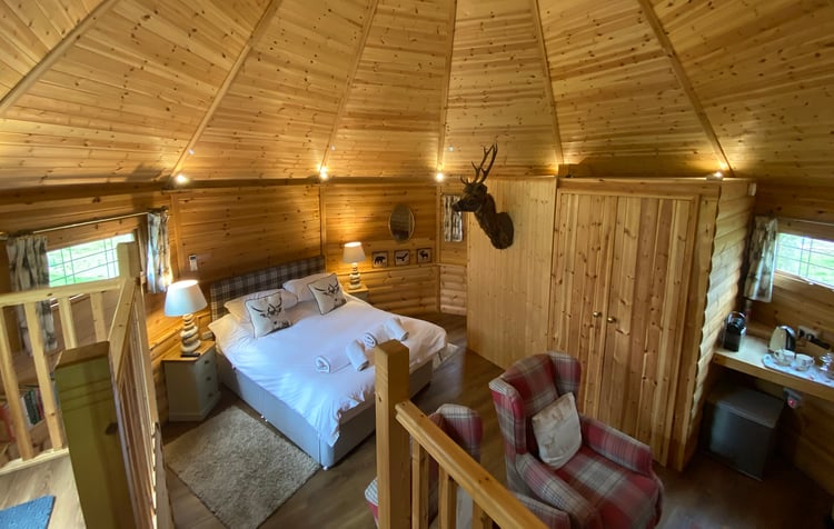 Interior of Timber Cabin Bedroom with bed, chairs & decor