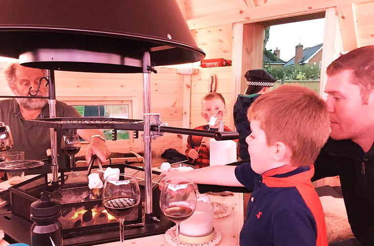 Interior of BBQ hut with family cooking marshmallows