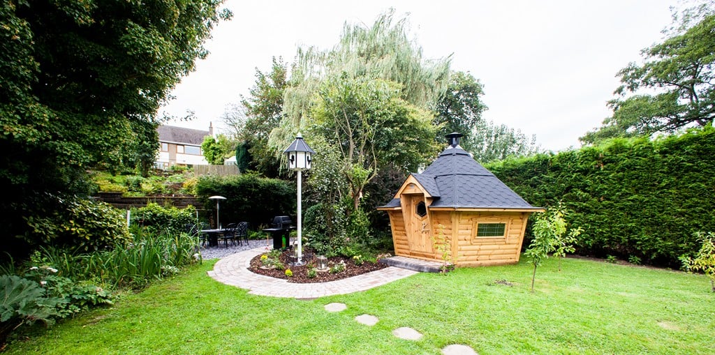 10m² Arctic Cabin with black roof within garden