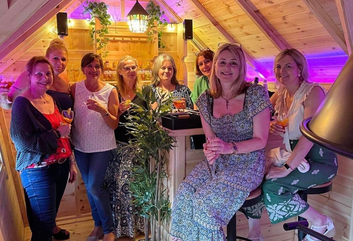 Group  of women enjoying drinks inside an Arctic Cabins garden bar
