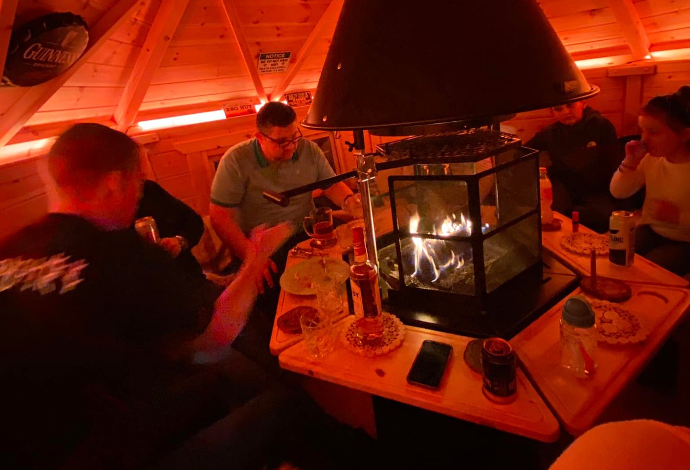 Family enjoying cooking around the BBQ inside an Arctic Cabin