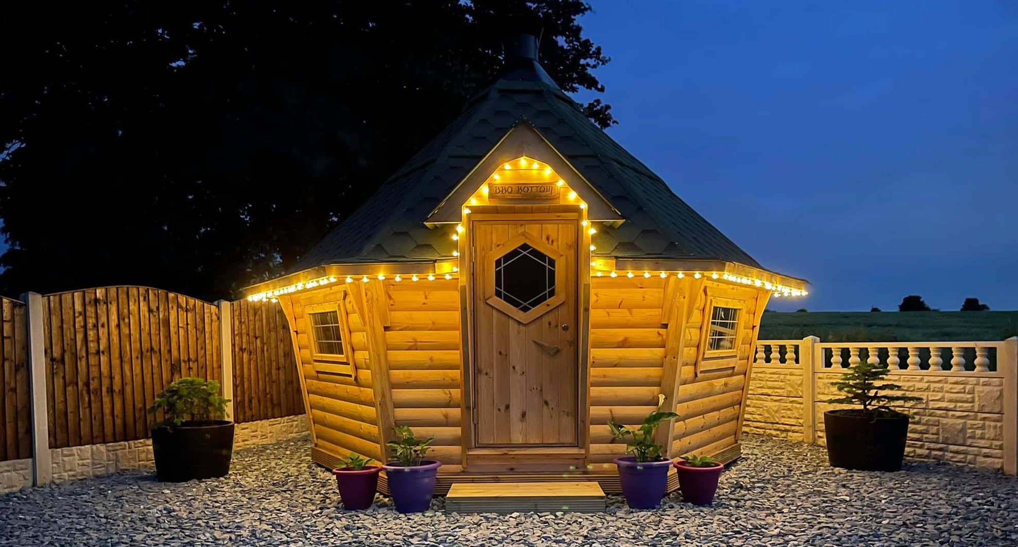 External night time shot of an Arctic Cabins BBQ huts lit up with fairy lights