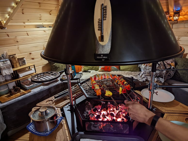 Interior of Arctic Cabin Grill Hut with BBQ lit and kebabs cooking over the heat