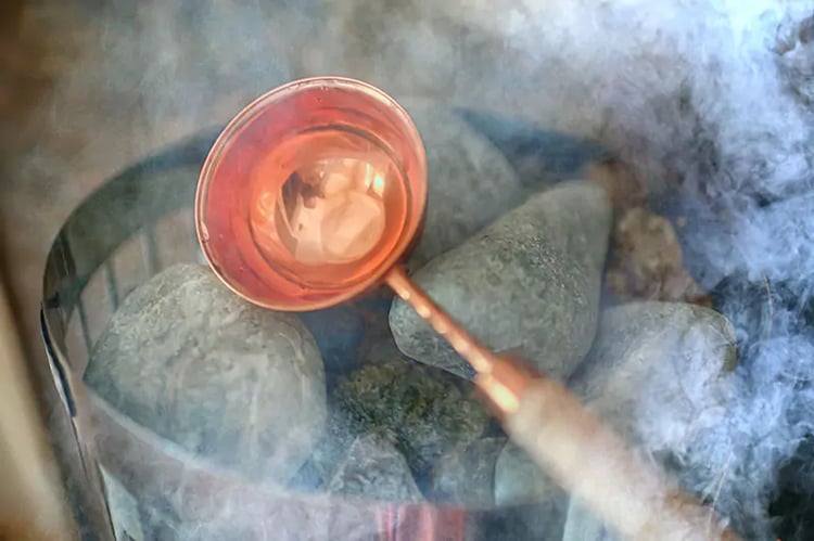 close up of water and coals inside a sauna cabin