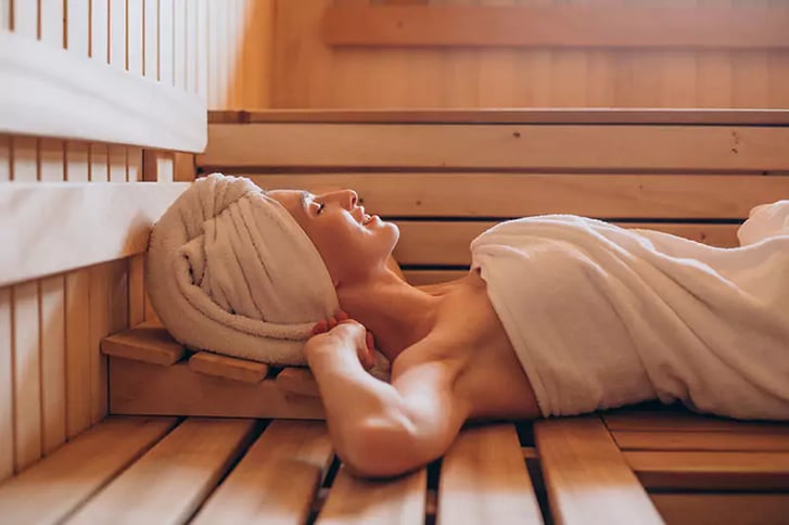 woman lying down inside arctic cabins sauna room
