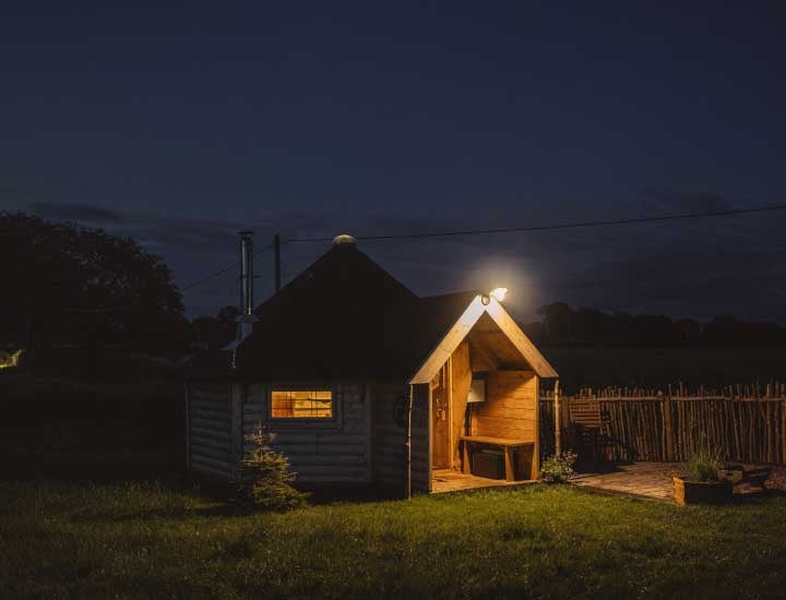 Exterior of Timber Arctic Cabins Hobbit House at nighttime