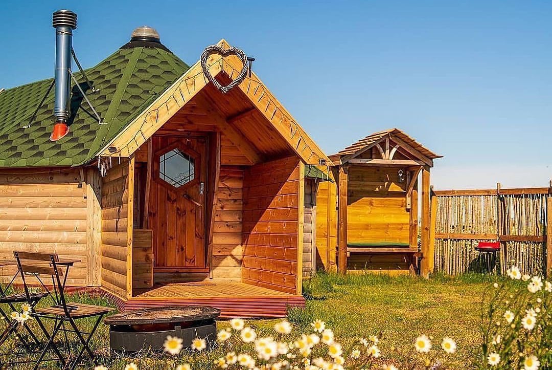 Glamping iste with Timber Arctic Cabins Huts on a sunny day
