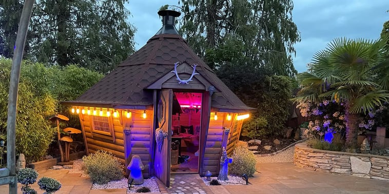 bbq cabin lit up at dusk with festoon lights