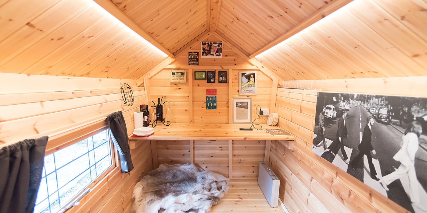 Internal shot of a garden office within a scandi style timber cabin, with integrated desk and reindeer skin rug